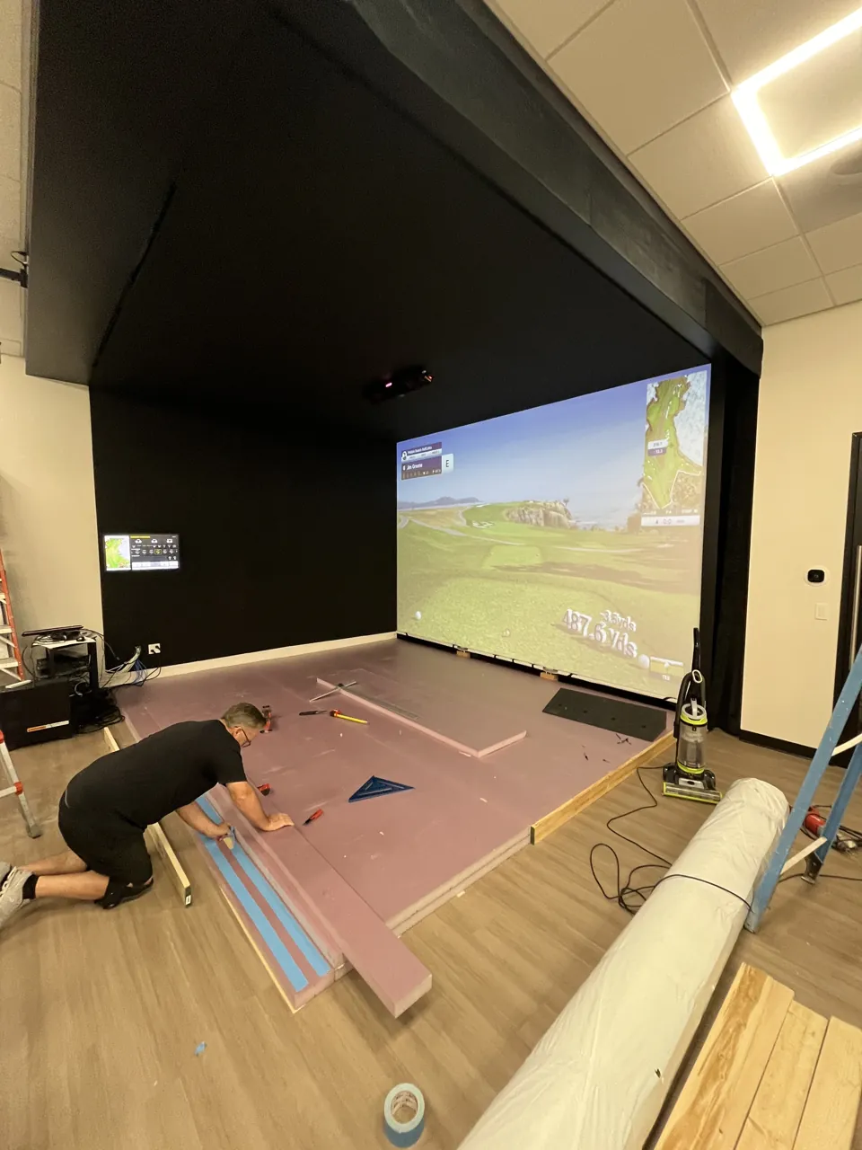 Flooring installation in progress at the G Brothers Construction golf simulator project