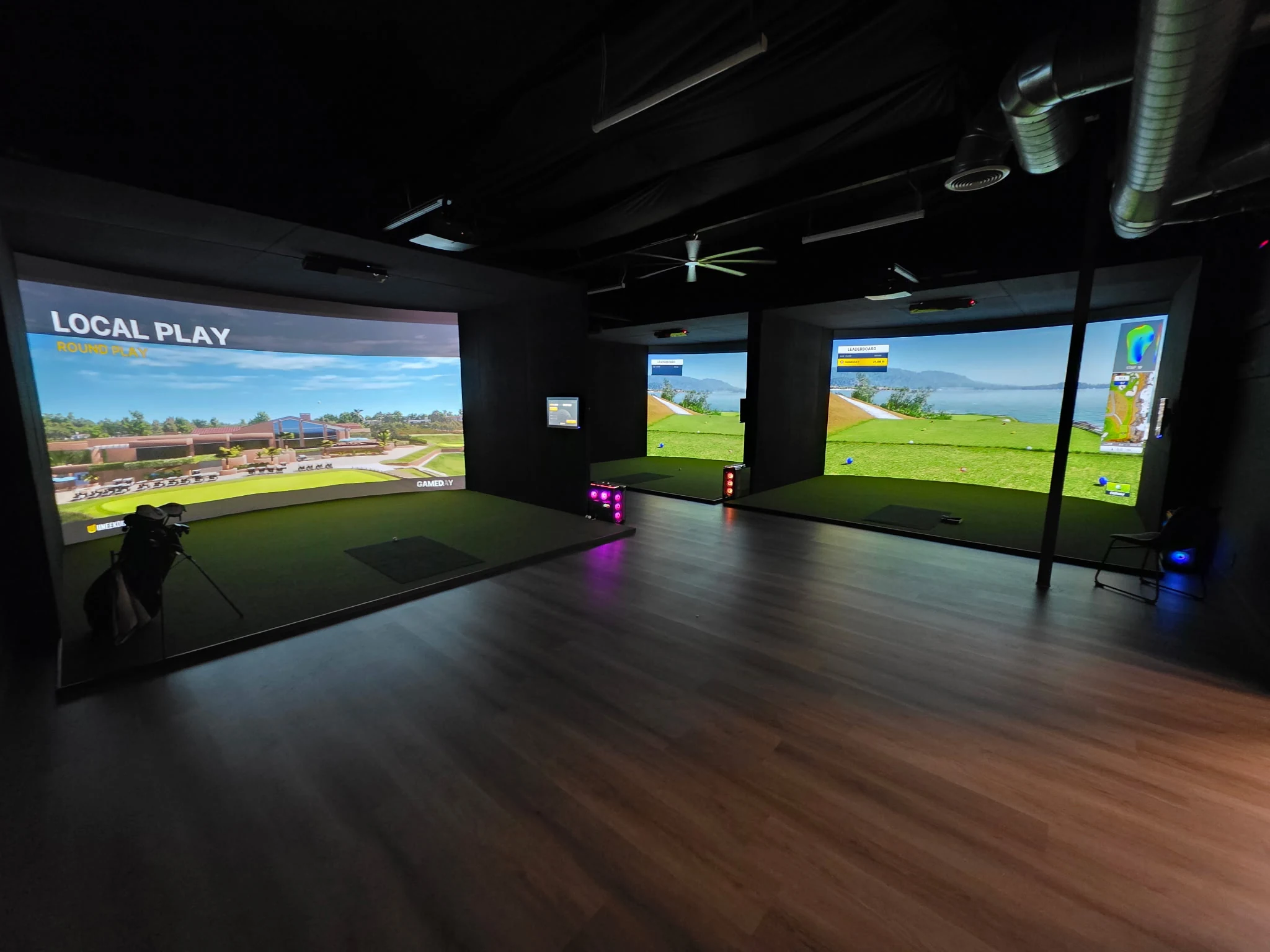 Multiple indoor golf simulator bays arranged within a commercial golf space