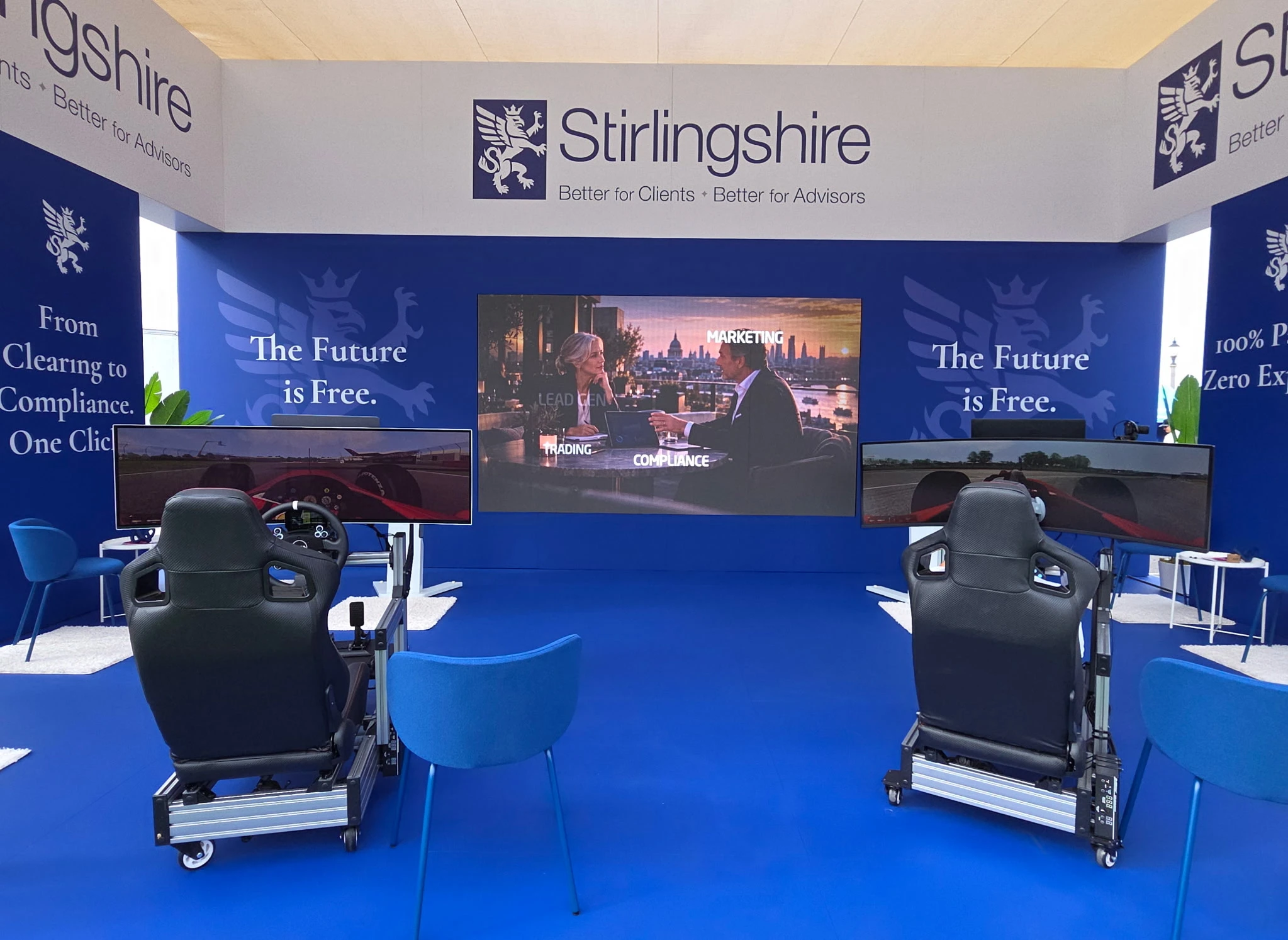 Two racing simulator chairs set side by side in a Stirlingshire branded event booth